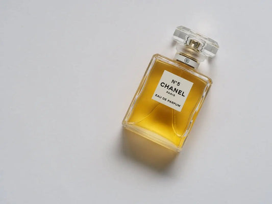 A bottle of Chanel No. 5 perfume lies on a horizontal surface