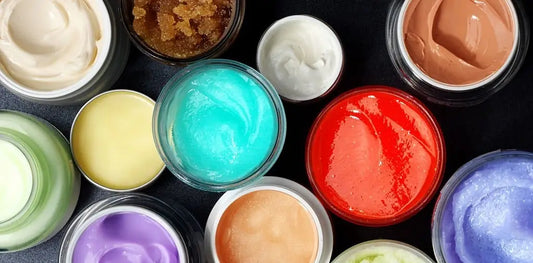 Some cosmetic jars of different sizes containing different brightly colored paints