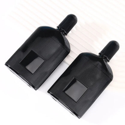 Two black perfume bottles with thin vertical stripes lying down