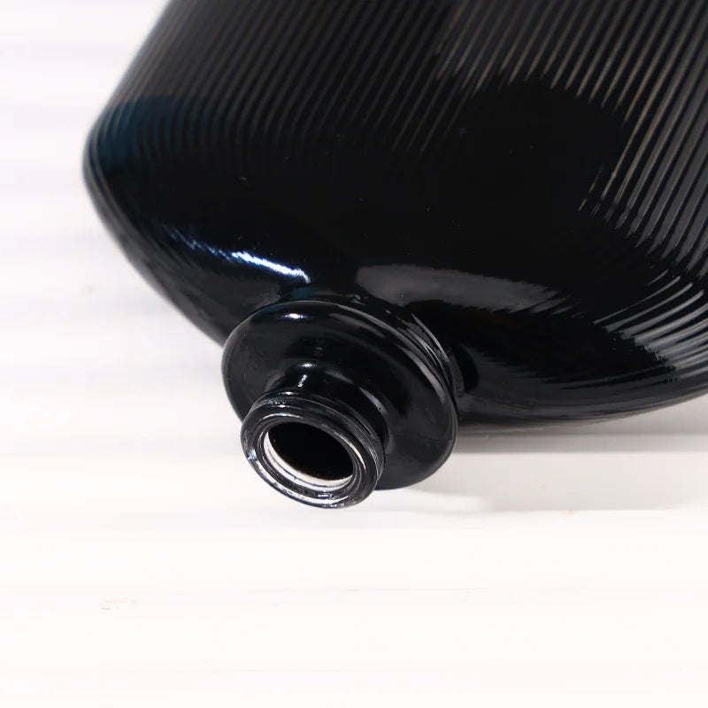 Detail of the mouth of a pure black perfume bottle with vertical stripes