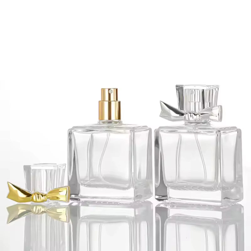 Bow Perfume Bottle Clear Glass with golden and silver bows on the caps