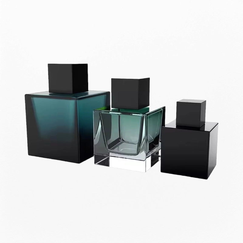 three cube perfume bottles with green and black color and black caps