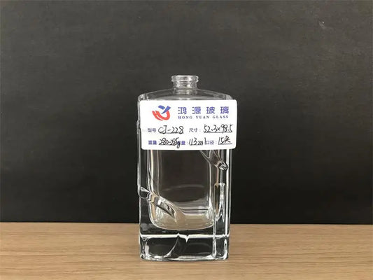 Square glass perfume bottle with a special design that looks like it is wrapped with a ribbon