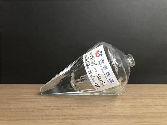 glass perfume bottle has a conical design with slight angular texture and a lying design.