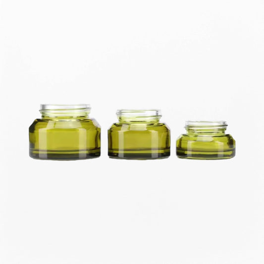 Three green empty cosmetic jars with different volumes