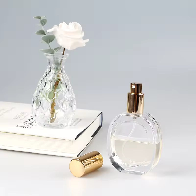 an empty glass perfume bottle stand by a book