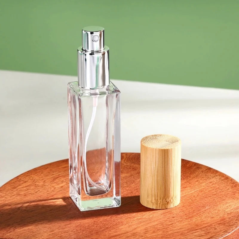 1 slim square glass perfume bottle with a bamboo cylindrical cap and silver spray head